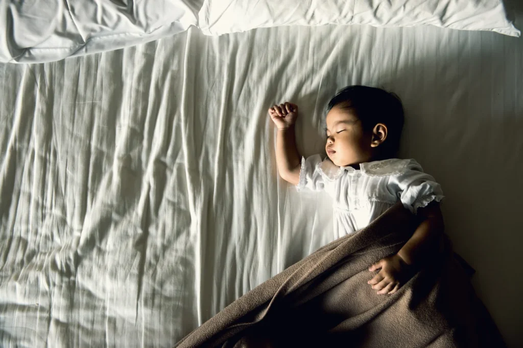 a baby asleep on a bed