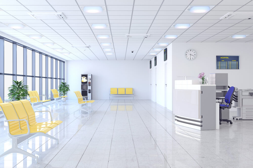 An office reception with yellow chairs and a nurse's station. The grid ceiling contains SkyView Tiles
